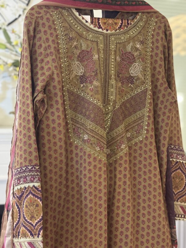 Close-up of the front of the khaki suit showing detailed embroidery and design.