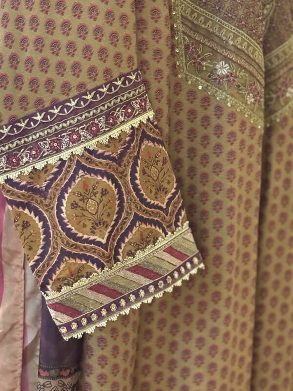 Detail of the sleeve of the khaki suit with decorative patterns and embellishments.