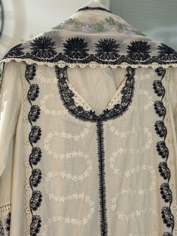 Close-up of the embroidered details on the white suit and dupatta.